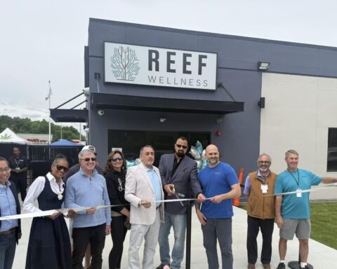 Mayor Chris Beauchamp, center, store owners and others cut the ribbon to open Reef Wellness on Sunday.