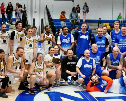 Players on the two teams at this year's charity basketball game gather for a group photo.