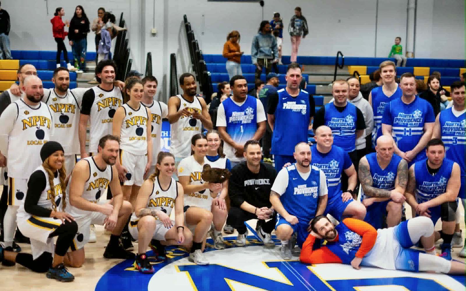 Players on the two teams at this year's charity basketball game gather for a group photo.