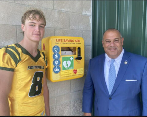Sen. David Tikoian with the two AEDs he contributed to Smithfield High School.