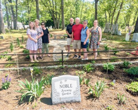 Cindi Noble, second from right, gathers with friends, family, staff members, and volunteers at the new serenity garden created in her honor.