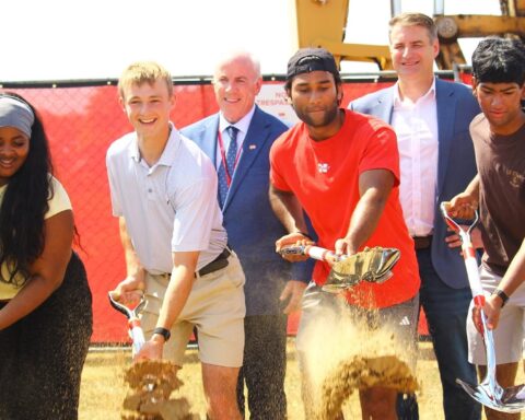 Youth symbolically throw shovels of sand to kick off the North Attleboro High School project on Friday, June 12.