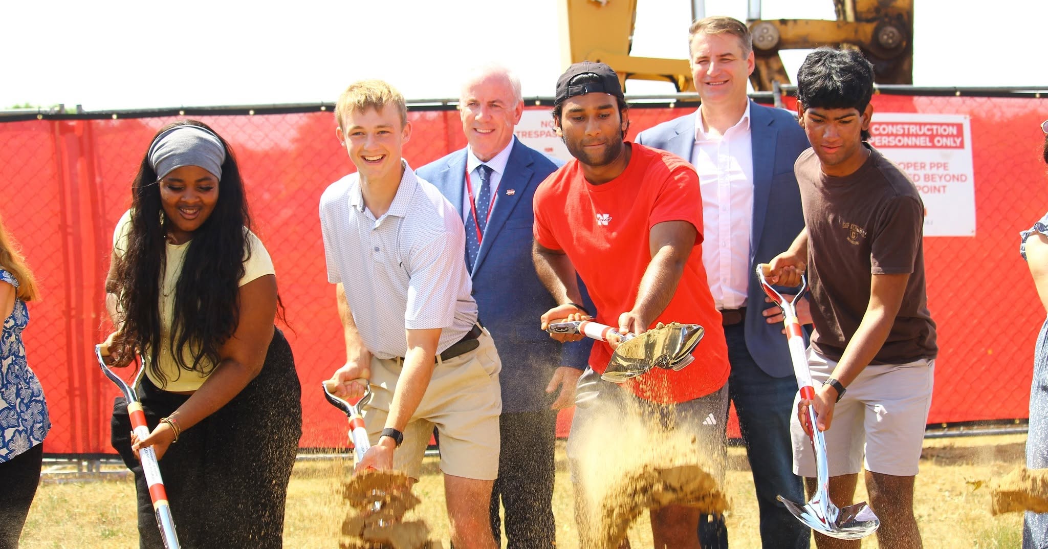Youth symbolically throw shovels of sand to kick off the North Attleboro High School project on Friday, June 12.