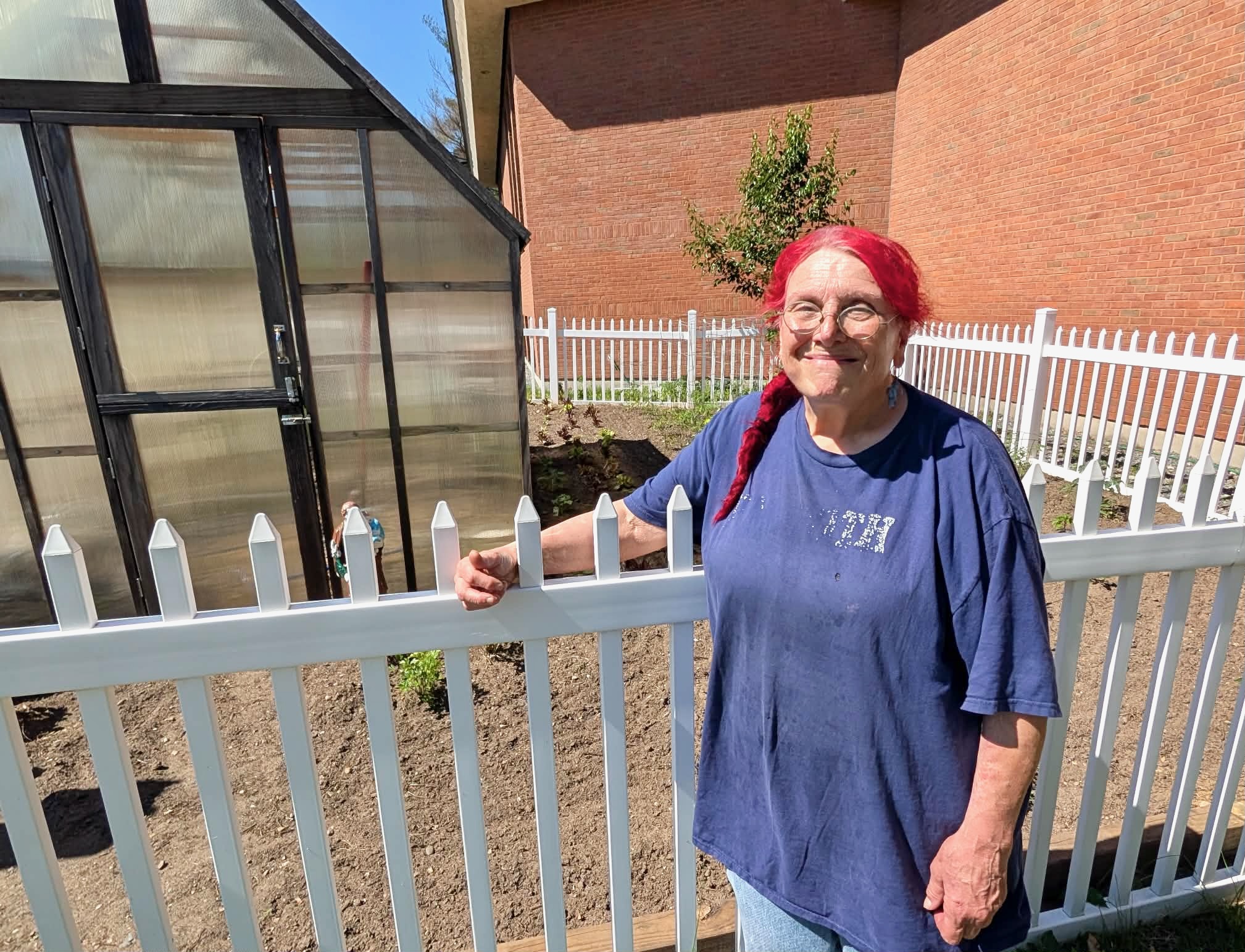 Adrienne Marchetti stands next to the garden where she grows much of the food she uses in her cooking.