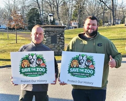Bob Bassill, vice president of the Capron Park Zoological Society, and Nick Lavoie, president of the group, with their famous signs.