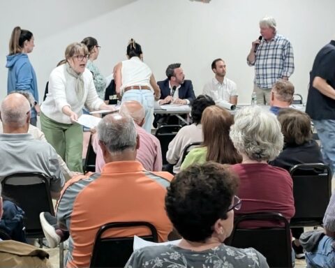 Andy Brown, right, questions Dylan Conley and Brad Clark as residents come up to the table to get the latest version of plans for 28 homes off Wilbur Road on Monday.