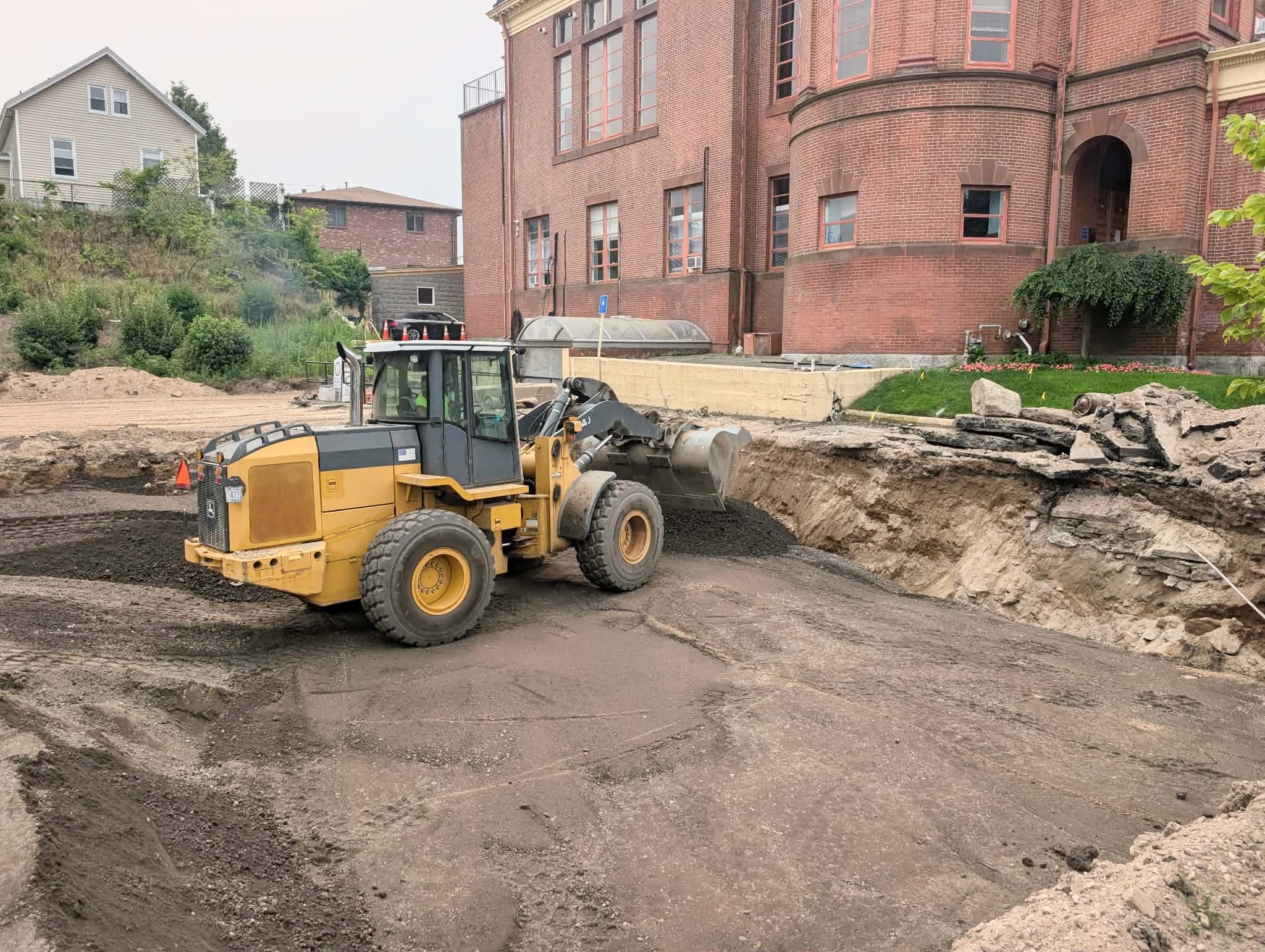 A heavy machine operator brings new dirt into the hole next to Cumberland Town Hall.