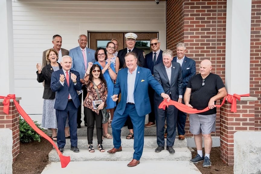 Town Administrator Phil Gould, surrounded by elected officials, cuts the ribbon to officially open the new facility.