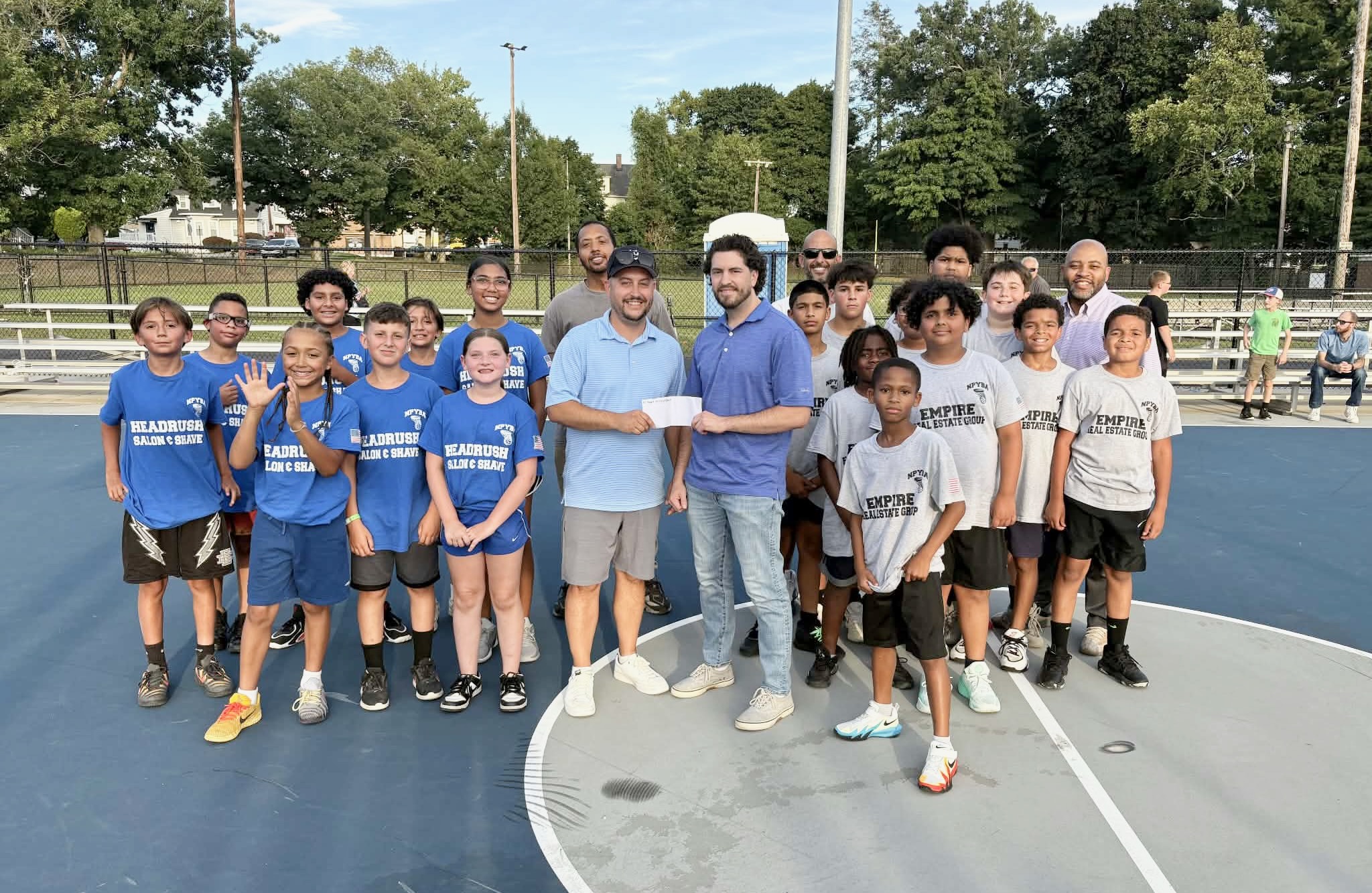 At Evans Park recently, Justin Conrad, center left, presented a check to local youth sports.