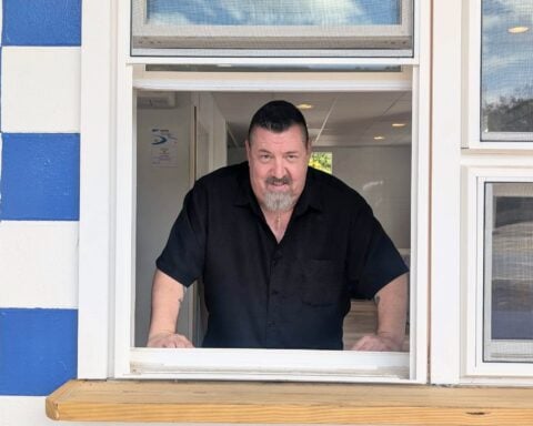 Bill Dreier in the window of his new sandwich shop. (photo by Ethan Shorey)
