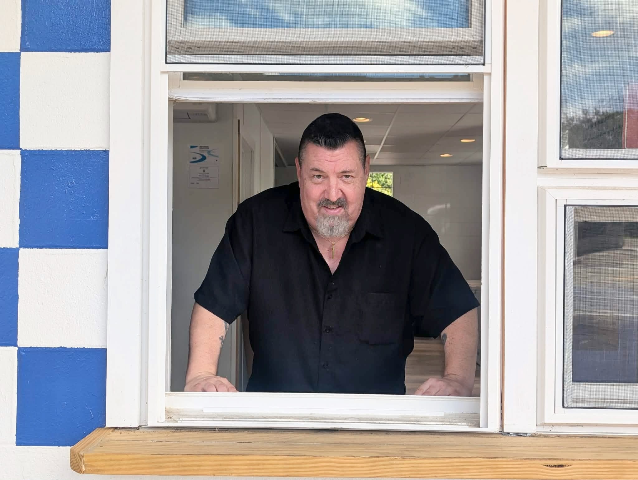 Bill Dreier in the window of his new sandwich shop. (photo by Ethan Shorey)