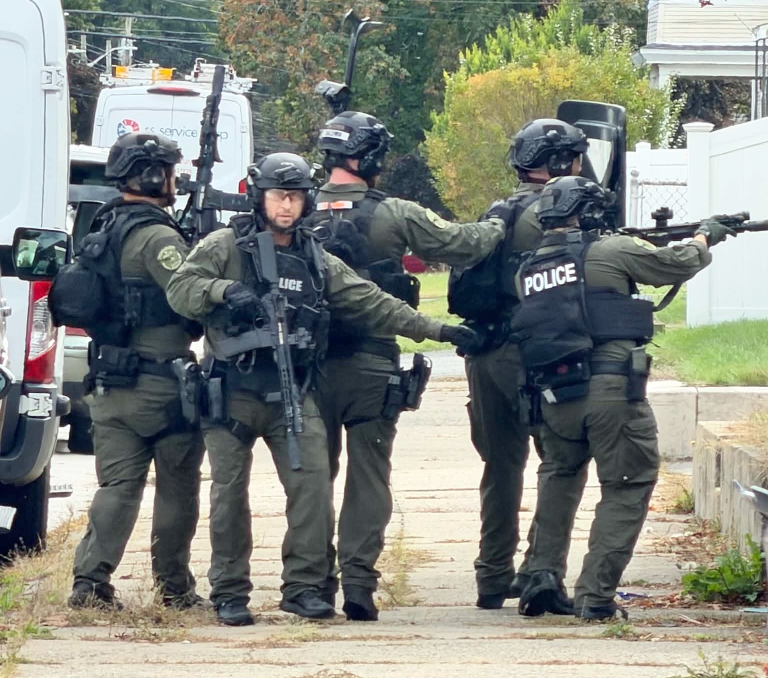 Officers respond with guns drawn on Rowe Avenue in Pawtucket Monday.
